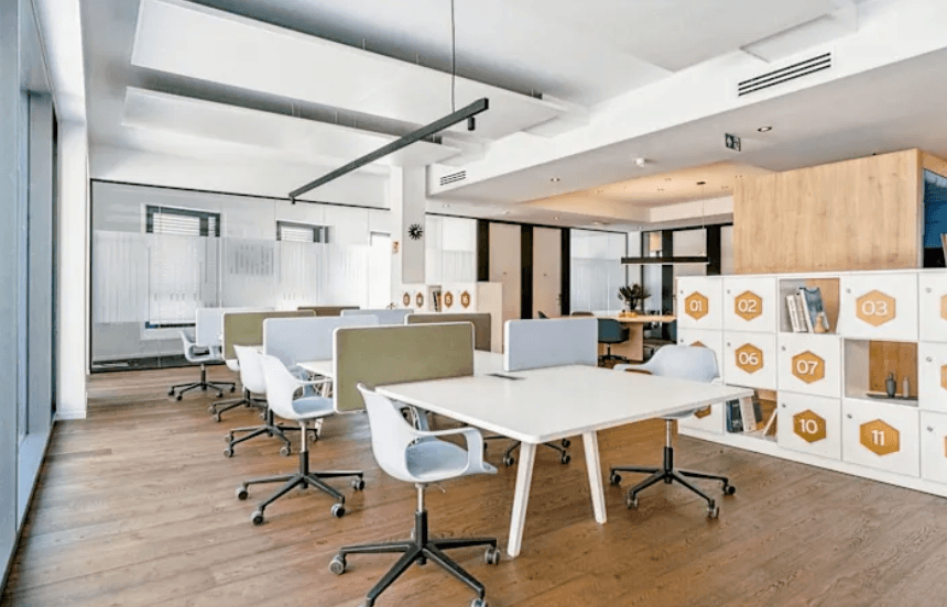 Moderner Webdesign-Arbeitsbereich mit mehreren Schreibtischen und offenen Regalelementen