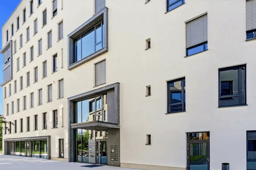 Außenansicht des modernen Bürogebäudes mit Eingangsbereich und großer Fensterfront